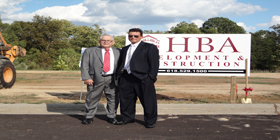 two men standing in front of HBA Development and Construction sign